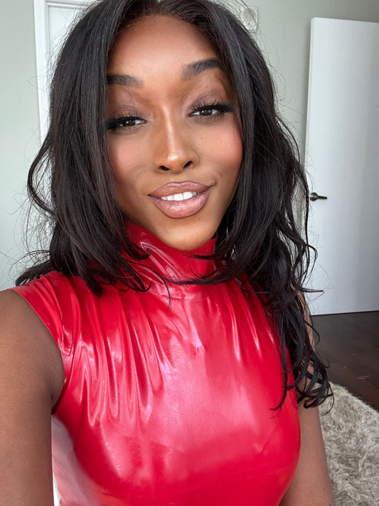 Jheanelle smiling in her red latex bodysuit