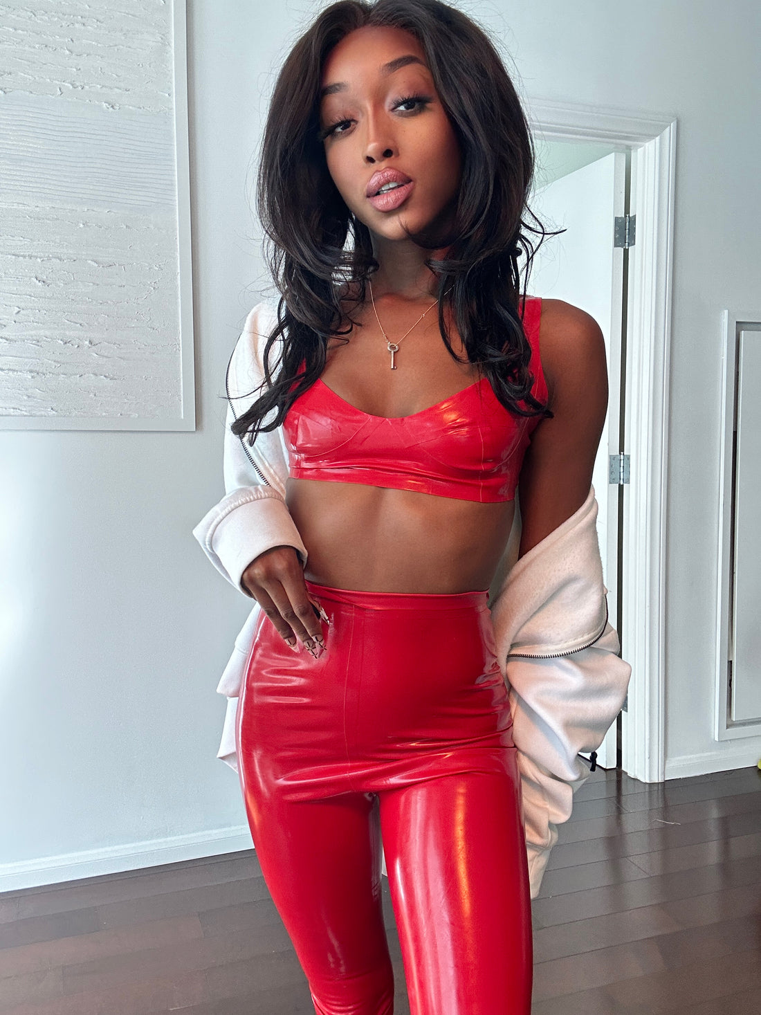 Jheanelle in a striking red 2-piece latex outfit, radiating confidence and allure